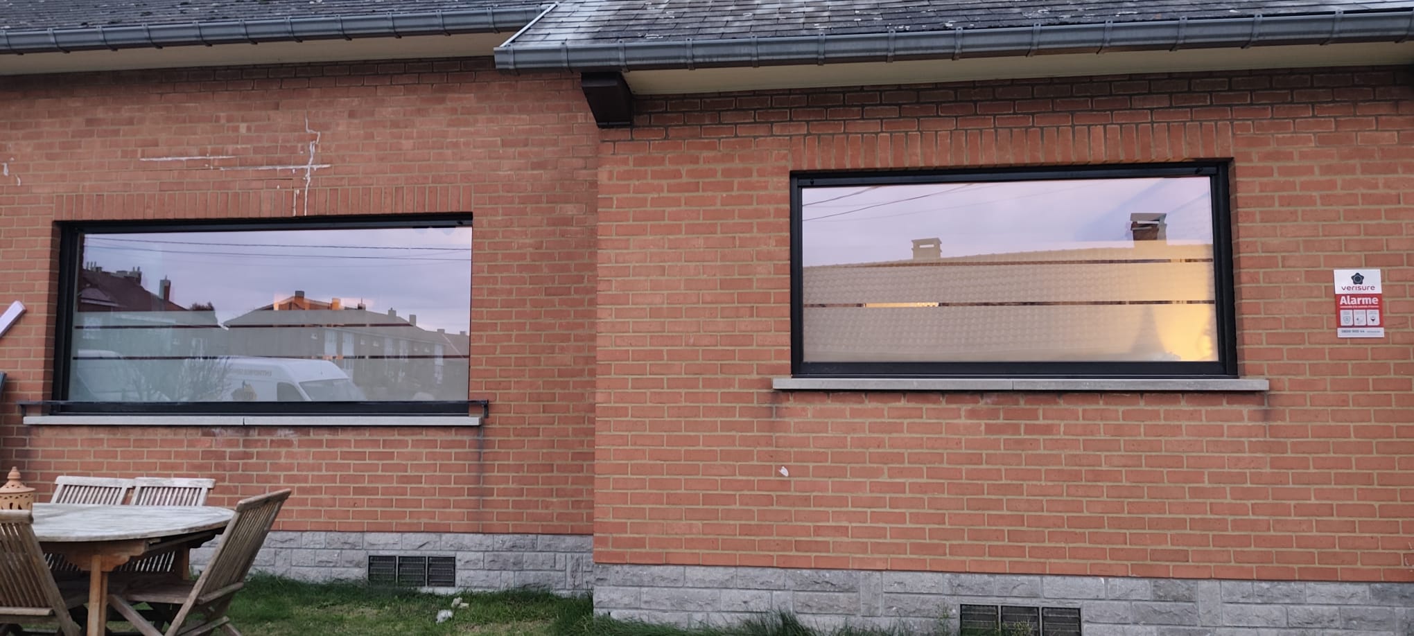 Façade en briques avec châssis foncé installé par VB Pro Châssis