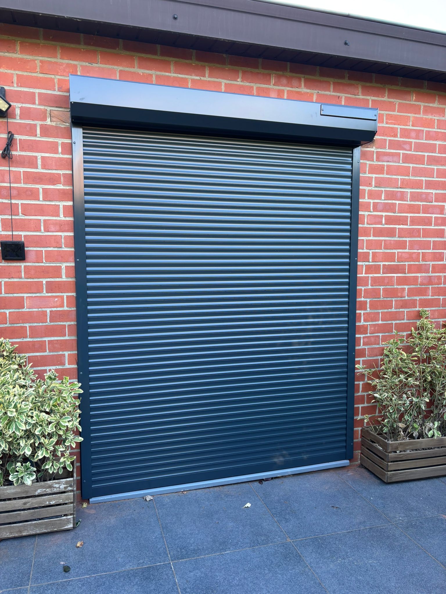 Volet roulant anthracite installé sur façade en briques - VB Pro Châssis