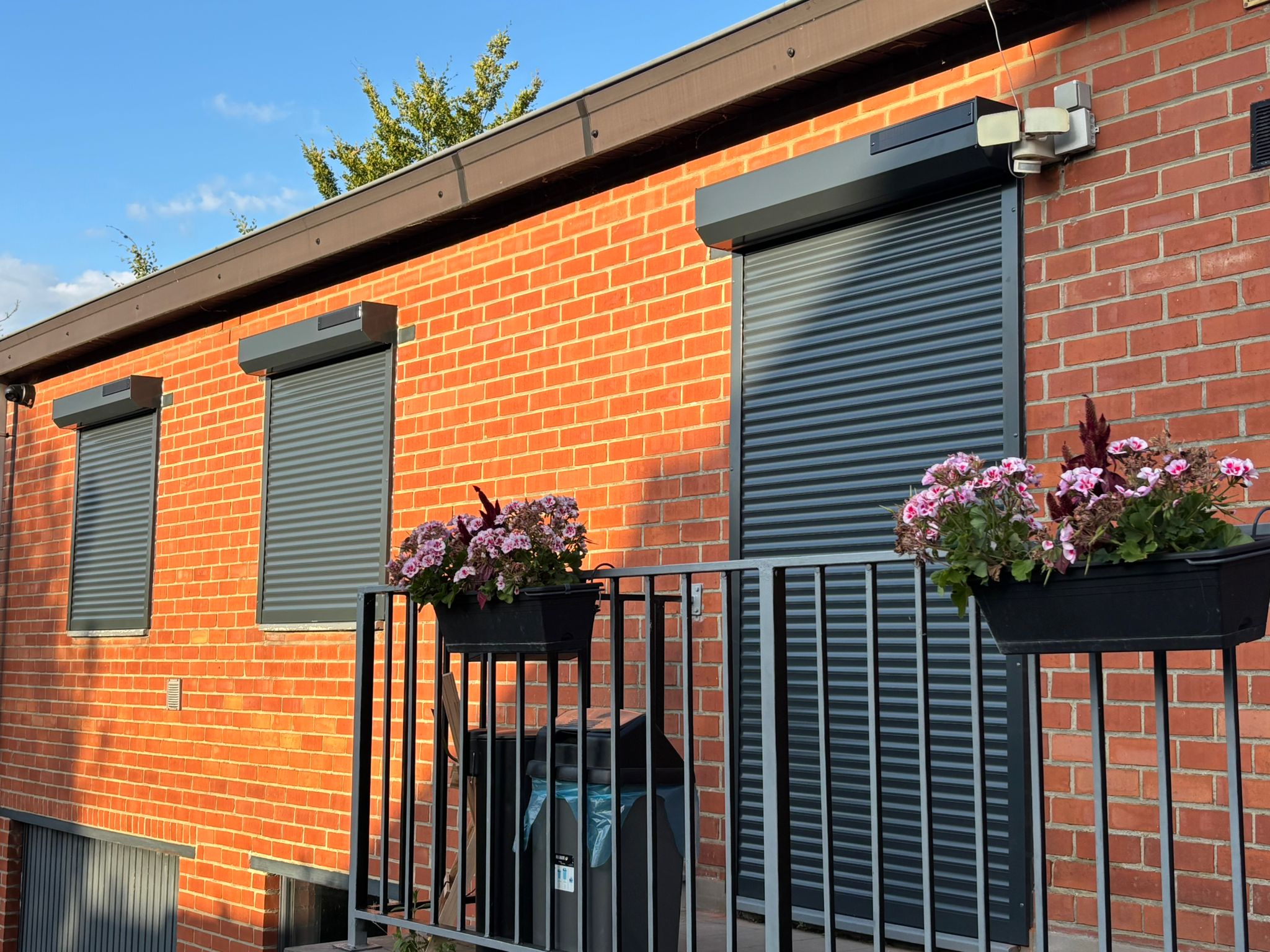 Façade en briques avec châssis et volets roulants installés par VB Pro Châssis